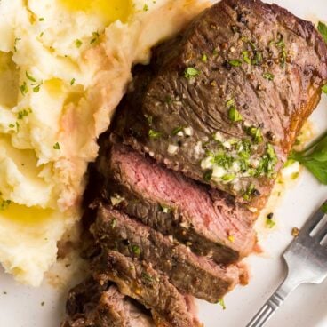 mashed potatoes on the side and sliced steak with garlic butter