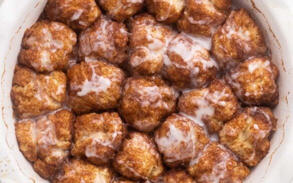 close up view of a round white dish filled with cinnamon roll bites.