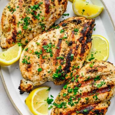 Top view of chicken on a platter that has had a Greek chicken marinade on it.