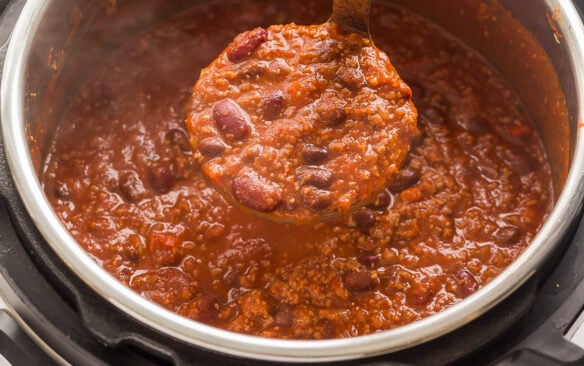 metal ladle scooping instant pot chili out of pot