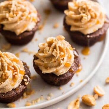 close up image of brownies bites drizzled with caramel and sprinkled with peanuts