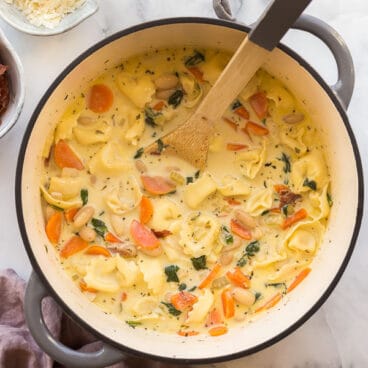 overhead image of spinach tortellini soup in grey dutch oven